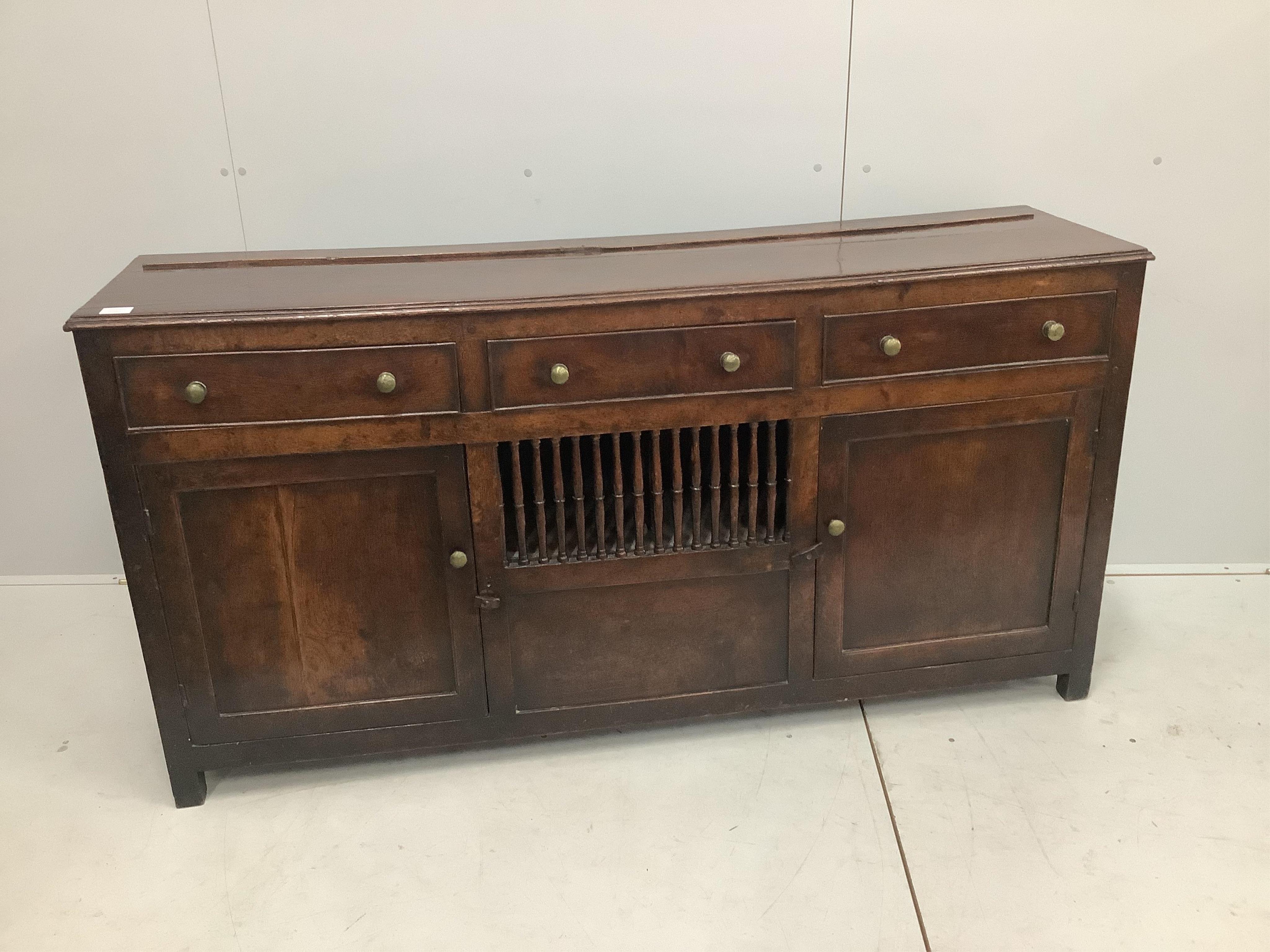 An 18th century North Wales oak enclosed dresser with central spindled glass or food compartment, width 163cm, depth 43cm, height 84cm. Condition - light wear but essentially good. Purchased from the specialist oak deale